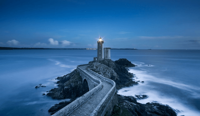 gray lighthouse on islet with concrete pathway at daytime, William Bout